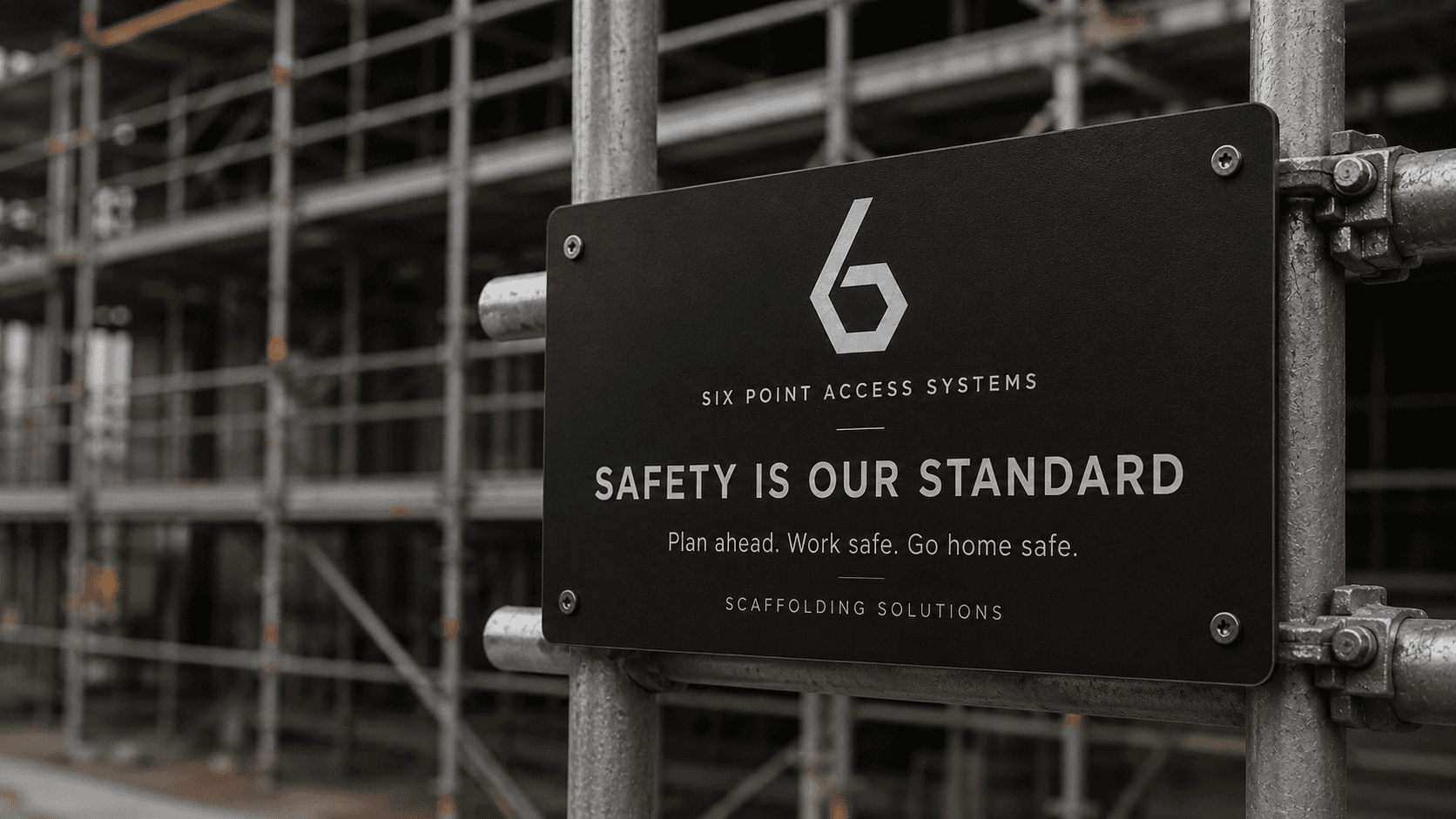 Site safety signage indicating PPE requirements at a scaffold work area